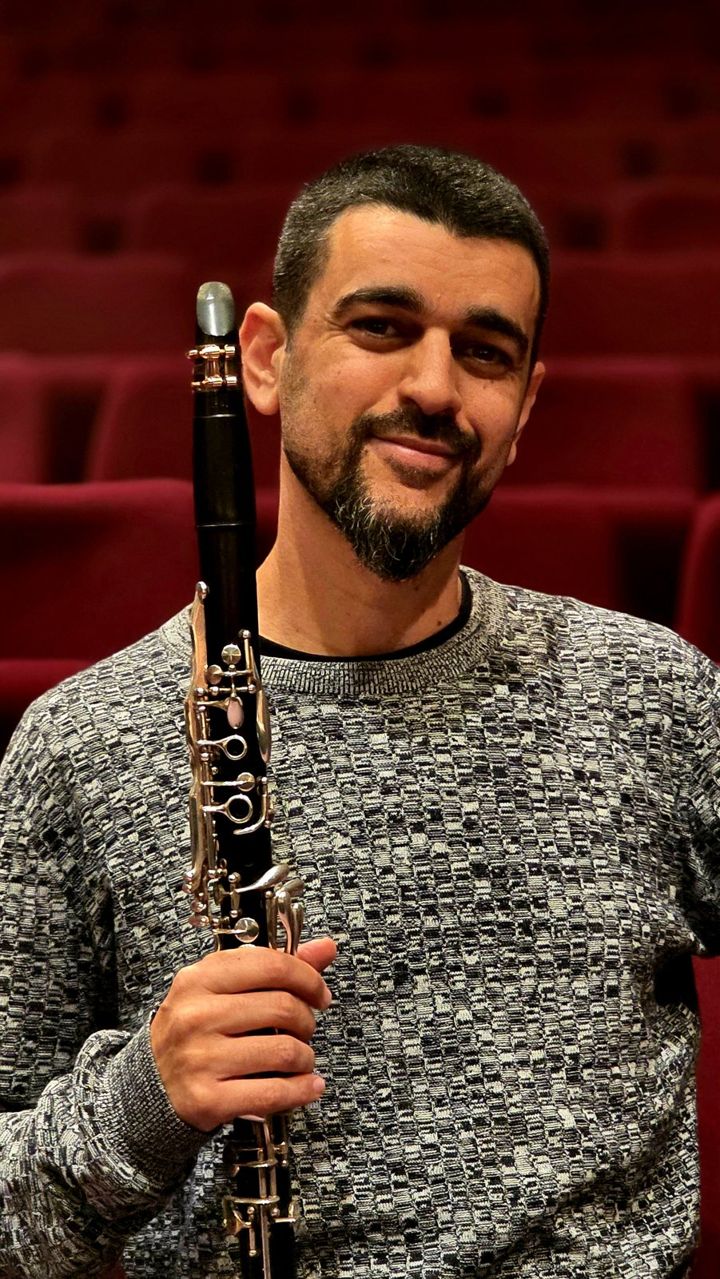 Nir Marom holding his clarinet in an empty concert hall